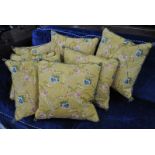 Seven yellow silk floral brocade cushions with piping and fringing (7)