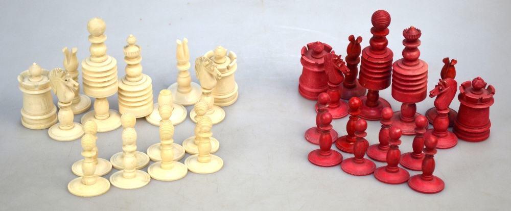 A 19th century ring-turned bone chess set with red dye, king 9.