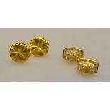 Two pairs of yellow metal earrings for pierced ears, one floral shape,