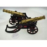 A pair of brass signal cannon with 29 cm barrels, on heavy cast iron carriages,