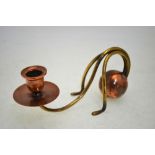 An Arts & Crafts copper and brass candlestick in the manner of W A S Benson,