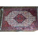 A Persian Hamadan rug, the cream ground centred by a geometric motif,