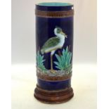 A tall majolica cylindrical vase on circular stand, decorated with tall waders, or other birds,