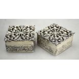 A pair of silver pomanders of square form with finely-worked foliate pierced covers and embossed