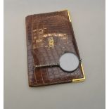 A Cartier brown crocodile leather full size wallet having 9ct yellow gold corners and initials,