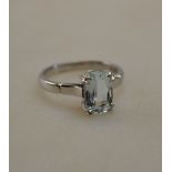 A rectangular aquamarine single stone ring in four double claw setting stamped 18ct