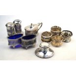 A matched silver five-piece condiment set of oval pierced design with blue glass liners,