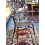 A 19th century elm seat Windsor elbow chair, the hoop back with wheel cut splat,