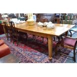 A substantial and large oak dining table, the cleated end top raised on square tapering legs,