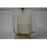 An Edwardian cotton lawn blouse edged with grey lace, a similar blouse with inset lace to sleeves,