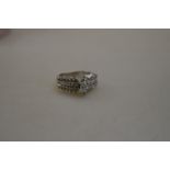 A pendalique-cut diamond ring having graduated baguette and brilliant cut shoulders,