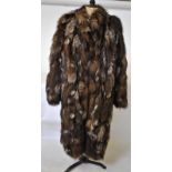 A light brown, flecked white fox fur coa