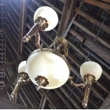 An Art Deco style brass three branch electrolier with opaque glass shades