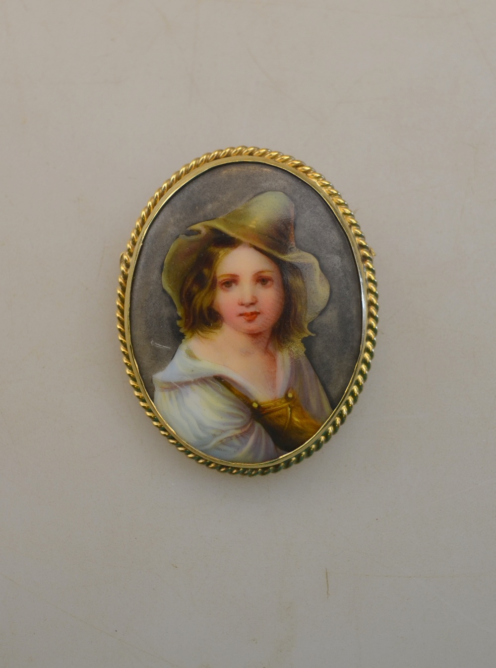 An oval porcelain plaque featuring femal