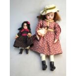 A small bisque-headed girl doll with bro
