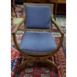 A late Arts & Crafts period oak framed armchair with fabric back panel and seat