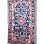 A Persian Hamadan region small carpet, the geometric design on dark blue ground,