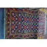 A Persian Veramin rug, the field of stylised linked flower heads on a mid blue ground,