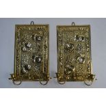 A pair of Victorian Aesthetic Movement brass plaque girandoles embossed with fruit and flowers in
