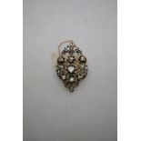 An antique rose diamond brooch of lozenge shape with pierced scrollwork,