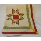 An early 20th century American hand-worked quilt, cream ground with repeating motifs in pale green,