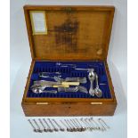 An oak canteen containing a mixed selection of electroplated fiddle,