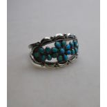 A Navajo silver and turquoise bracelet with floral design, about 5.