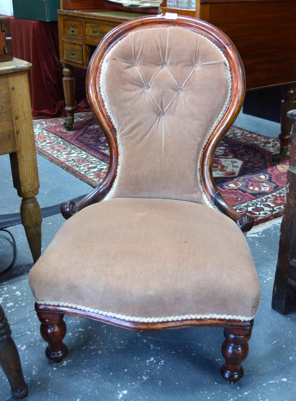 A Victorian mahogany framed buttoned spoonback nursing chair with overstuffed serpentine seat