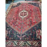 A Persian Hamadan rug, the stylised centre medallion on mid-red ground,