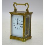 An English brass carriage clock with enamel dial, 15 cm high (including handle),