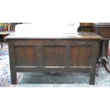 An 18th century joint oak coffer, the two plank staple hinged top over a carved frieze,