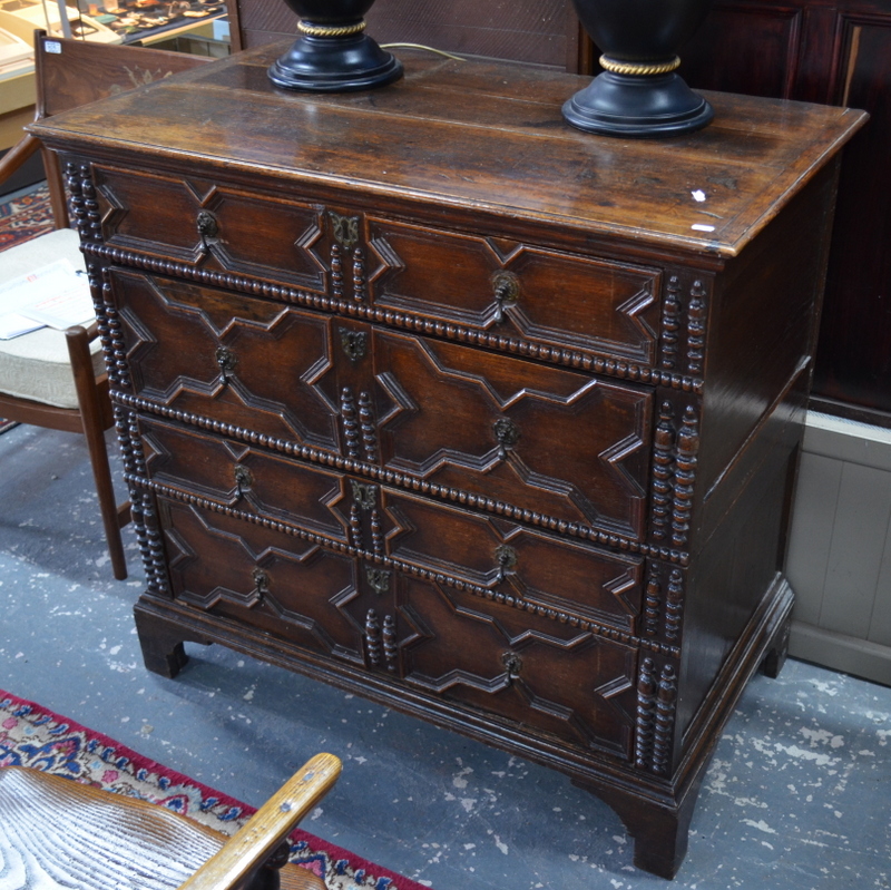 An early 18th century oak joined chest of four long graduated drawers, in two sections,