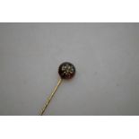 A Victorian stick pin of circular almandine garnet with diamond set bee in centre,