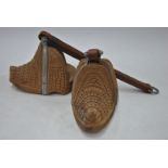A pair of Chilean ornate carved wood stirrups with leather straps,