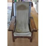 An Arts & Crafts period oak framed plantation style chair with velour sling seat and hinge over