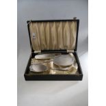 A cased silver four-piece brush set with engine-turned and engraved decoration,