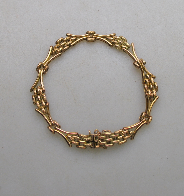 A yellow metal three-row gate style bracelet having concealed snap, stamped 9C,