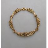 A yellow metal three-row gate style bracelet having concealed snap, stamped 9C,