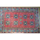 A Caucasian Kazak style rug, the re ground with geometric panels and flower heads,