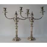 A pair of electroplated twin-branch candelabra on baluster pillars and circular bases