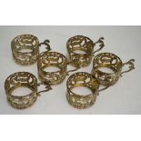A set of six embossed and pierced silver coffee can holders with scroll handles,