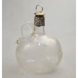 A Victorian glass wine bottle with wheel-etched vine decoration and vine-embossed silver collar and
