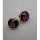 A pair of circular amethyst earrings with hook fittings for pierced ears, yellow metal setting,