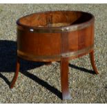 A late Victorian/Edwardian mahogany oval planter of coopered form raised on four long staves to