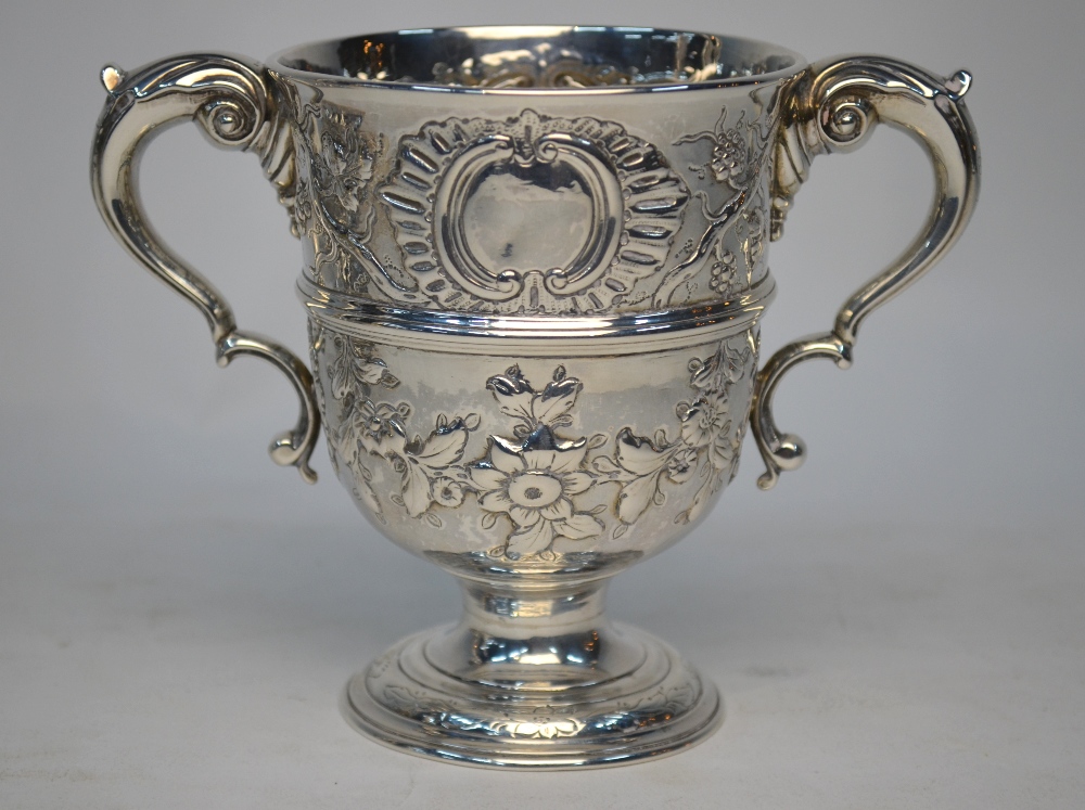 A 19th century two-handled loving cup in the Georgian manner, embossed with vines and rose garlands,