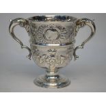 A 19th century two-handled loving cup in the Georgian manner, embossed with vines and rose garlands,