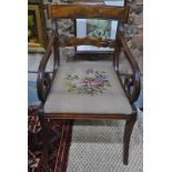 A Regency figured mahogany scroll arm carver with needlepoint seat,