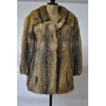 A tawny-toned fox fur and suede trimmed three-quarter coat retailed by J & M Lybeer, Brugge,