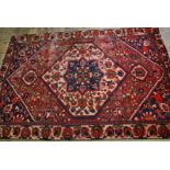 A Persian Baktiari small carpet, the pink-red ground centred with a geometric medallion,