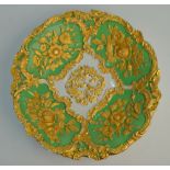 A Meissen shallow bowl, green ground, having gilt ornate moulded decoration,